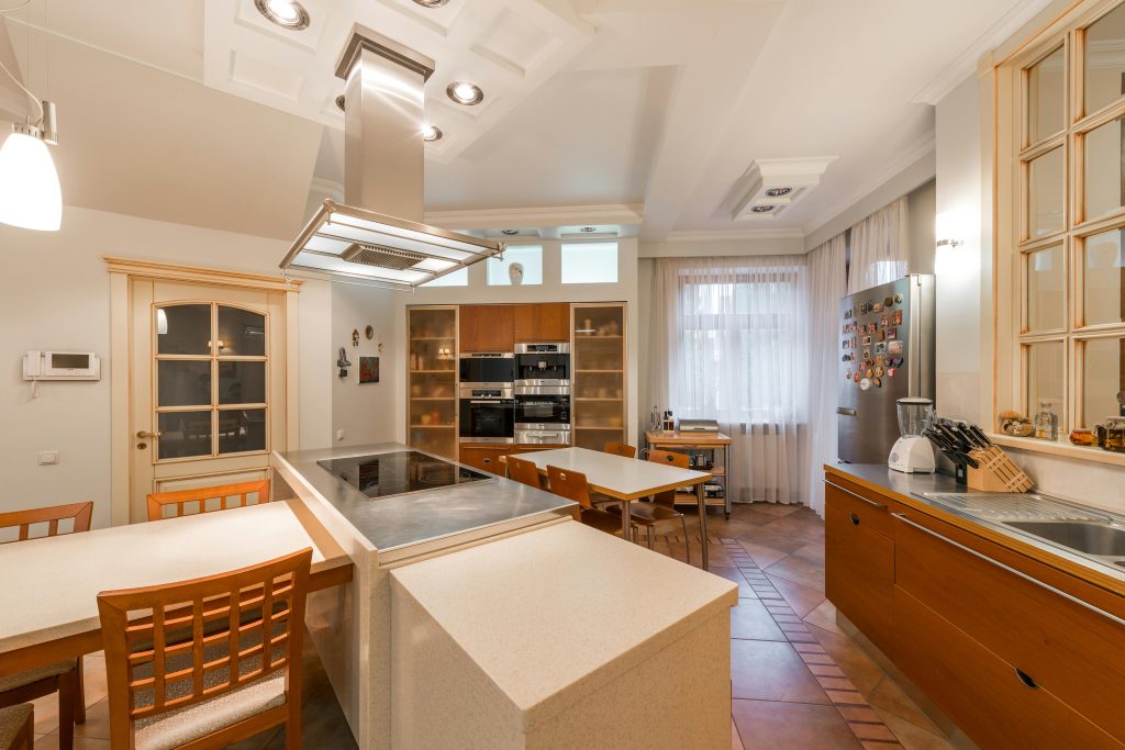 A cozy and stylish kitchen featuring contemporary furniture and appliances with warm lighting.